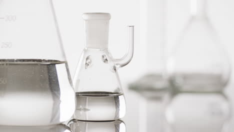 video de primer plano de vasos y platos de laboratorio de vidrio con espacio de copia en fondo blanco