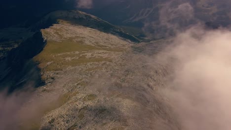 toma panorámica a través de las nubes con montañas debajo