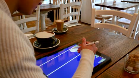 over shoulder view of woman working on a tablet