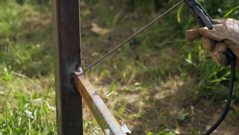 close view builder welds rail to pole with sparks and smoke