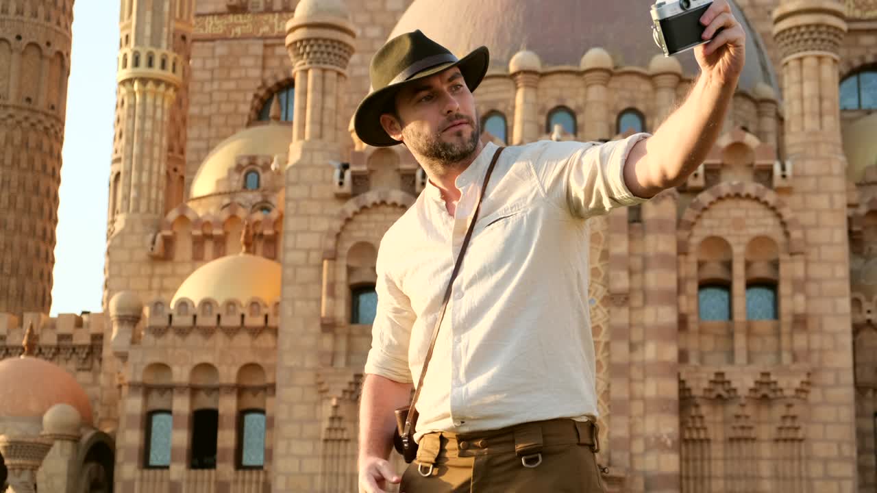 un turista se para con una cámara cerca de la mezquita, minaret.arqueología