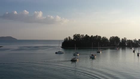 Sailboat-sailing-towards-paradise-101-next-to-seratos-island-near-telaga-harbor-marina-at-langkawi-island,-kedah,-archipelago-of-malaysia,-cinematic-aerial-shot