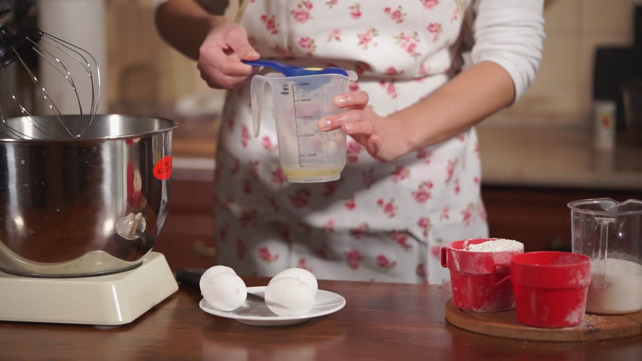 mujer horneando con tazas de medición y mezclador de soporte