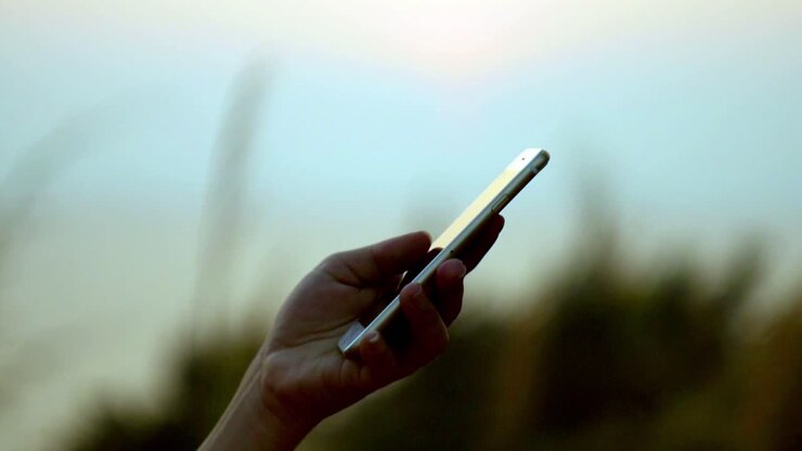 Weibliche Hand scrollt draußen auf einer Smartphone-Anwendung - isoliert