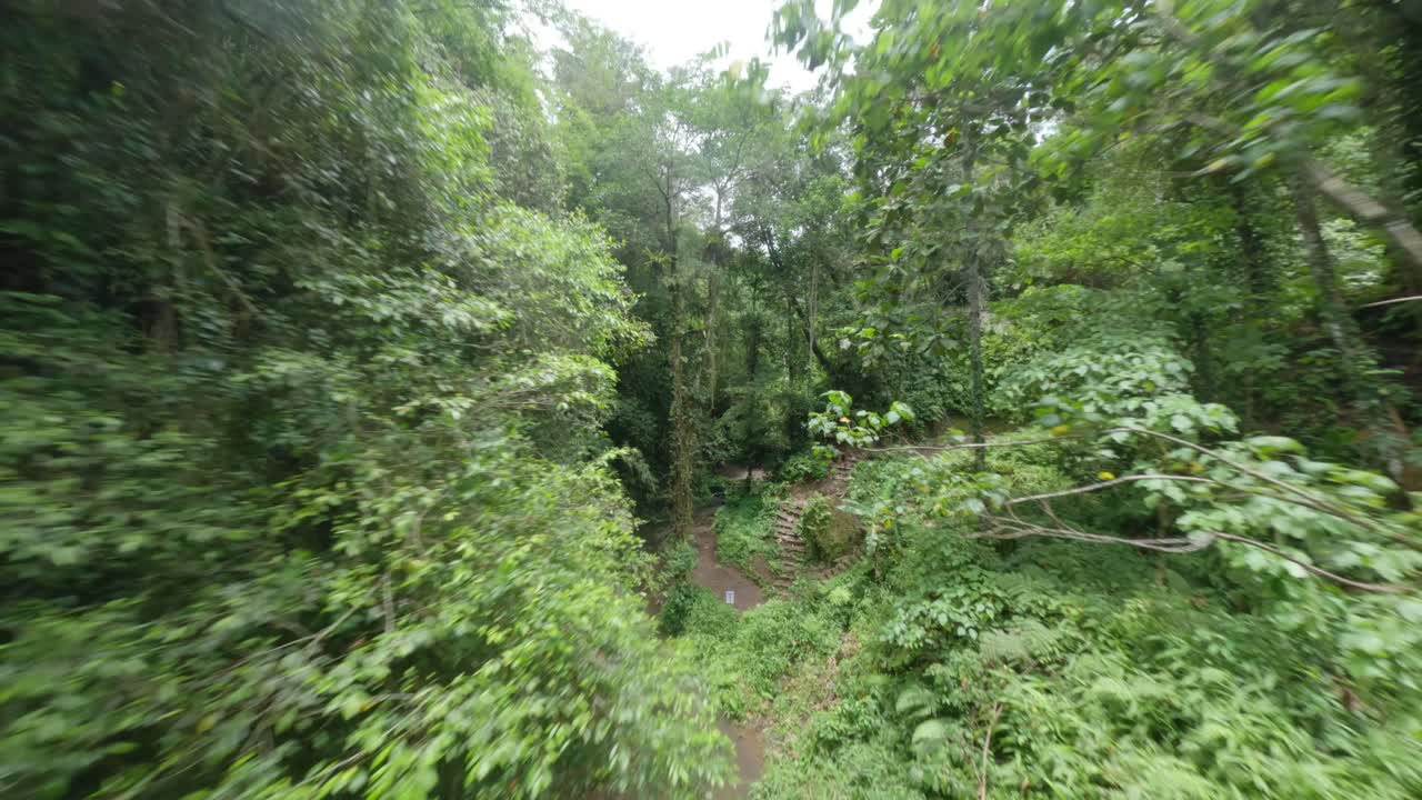 bella mujer rubia sentada en bikini en la naturaleza junto a la cascada de manuaba