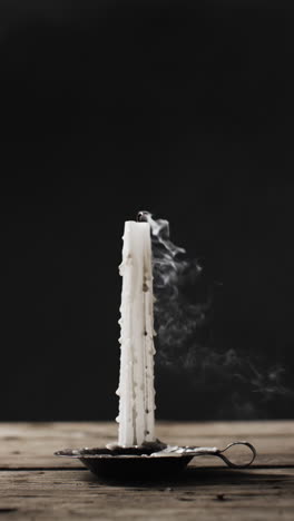 vertical video of halloween candle being blown off and smoke with copy space on black background