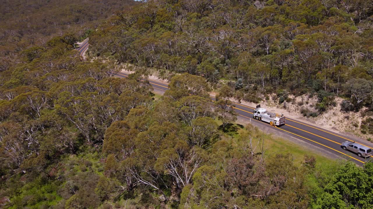 panning drone toma de un camión que pasa por la carretera alpina en el área de crackenback, australia
