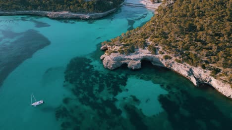 Clear-turquoise-blue-sea-water,-sailing-ship-boat-in-a-remote-bay,-Palma-de-Mallorca-Island