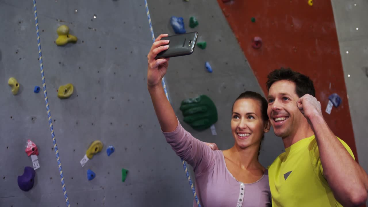 hombre y mujer tomando una selfie en el gimnasio de bouldering 4k