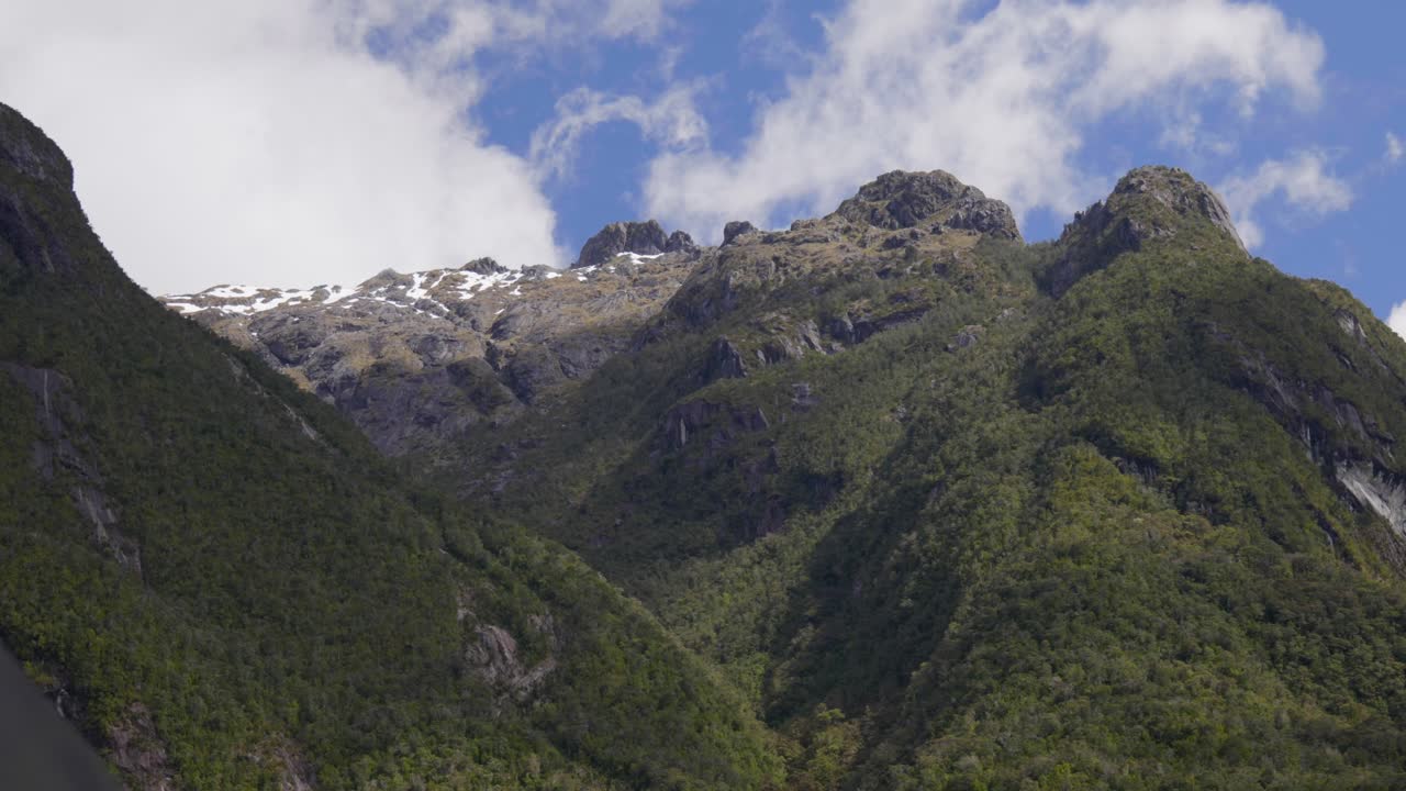 Campo lungo di alte montagne rocciose che si ergono sopra Doubtful Sound, rivelando fiordi spettacolari, vaste dimensioni e natura selvaggia incontaminata in un paesaggio alpino remoto