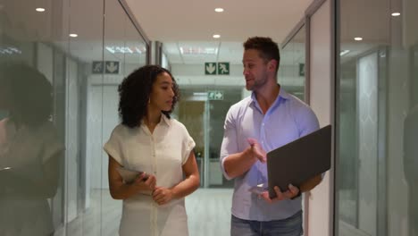 young office executives discussing over laptop in a modern office