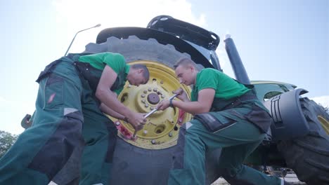 farmer mechanic repairing tractor. open tractor hood, engine. repair agricultural technology