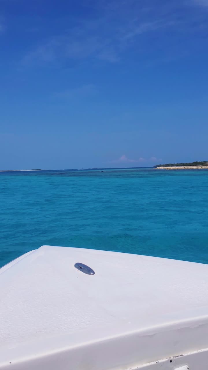 POV sailing white vessel boat on caribbean sea water with tropical island background