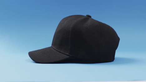 Video-of-black-baseball-cap-and-copy-space-on-blue-background