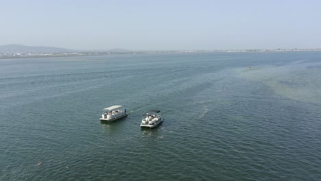 two boats coasting on the sea beside seabanks in lovely azure waters on a warm summers day