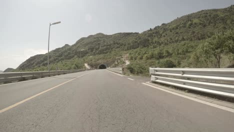 pov driving through empty road tunnel then exiting.