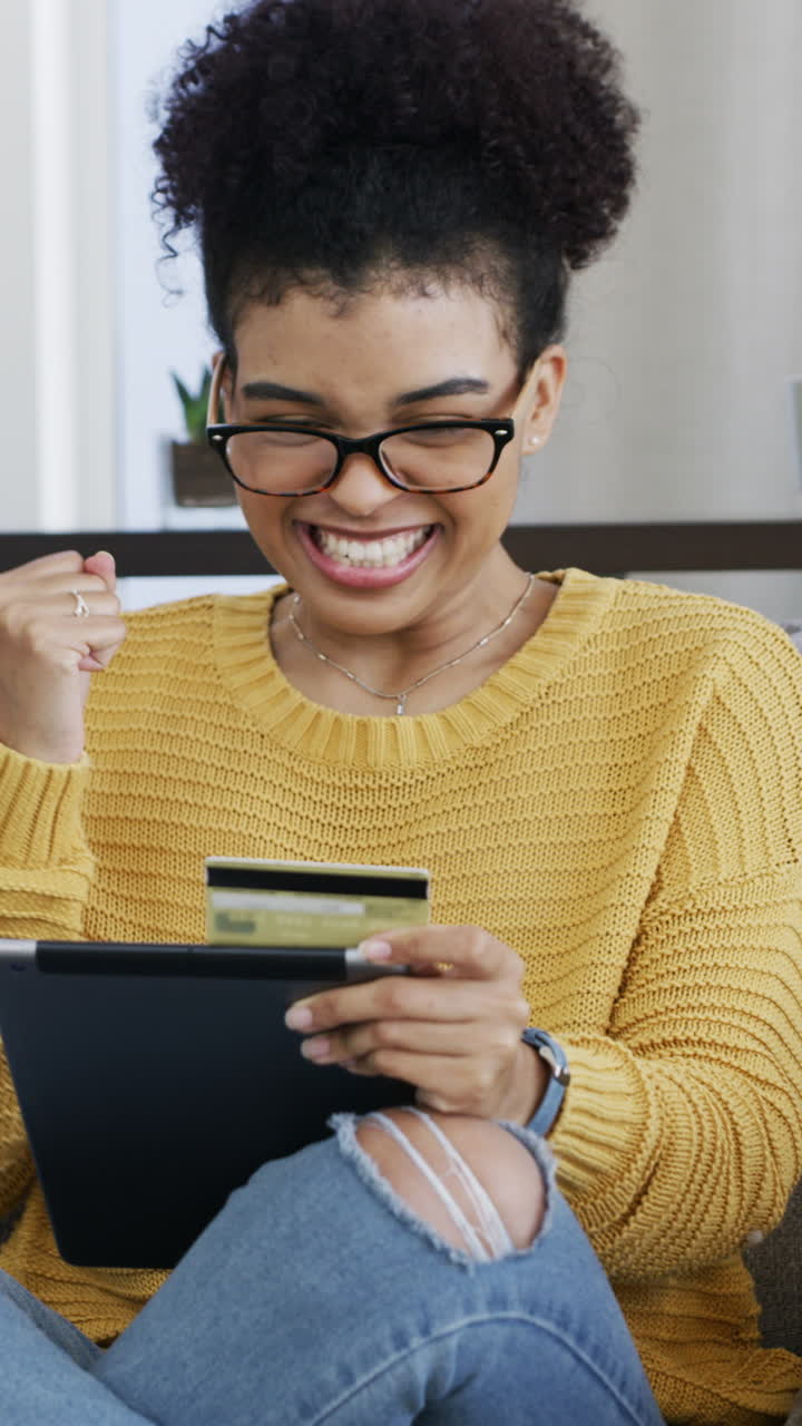 Giovane donna felice che effettua un acquisto online con carta di credito e tablet