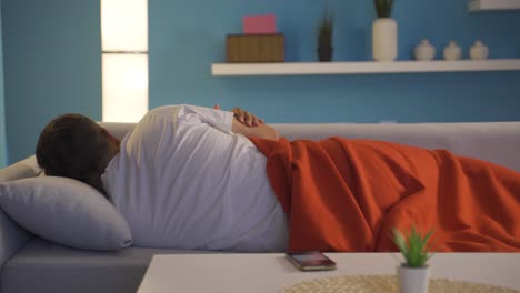 hombre posponiendo el despertador en su sueño.