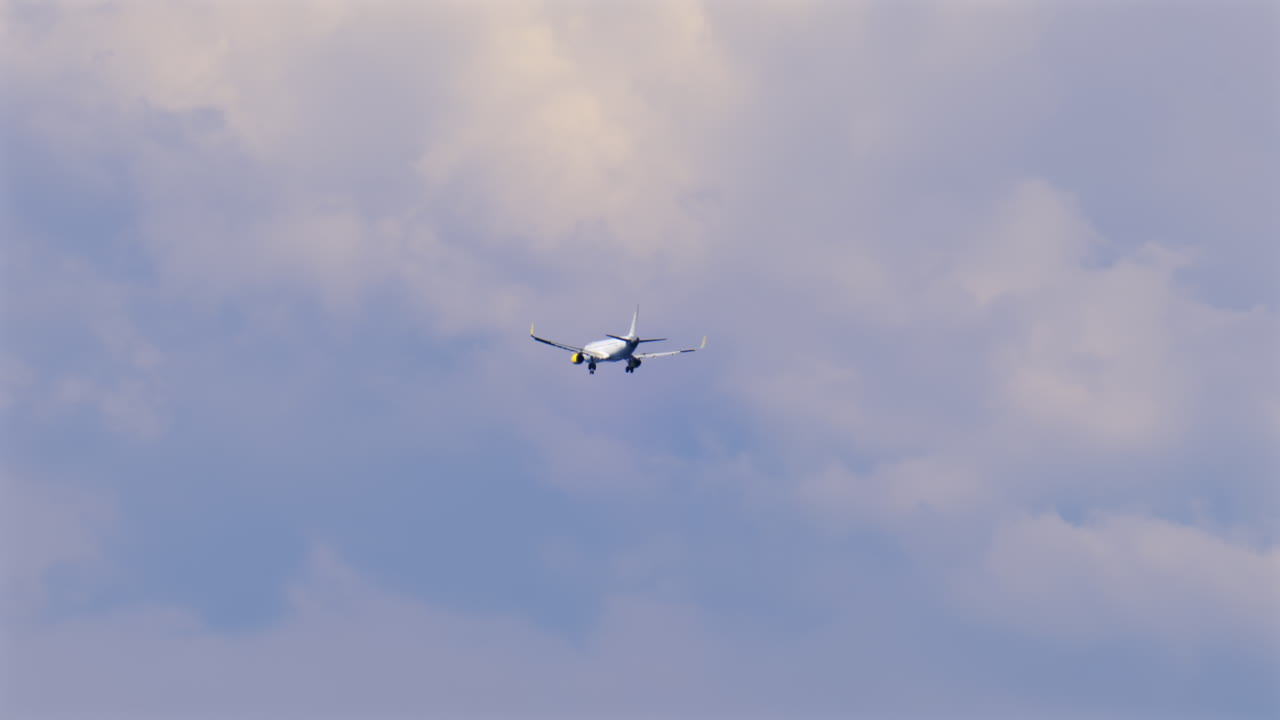 View of an airplane flying on the cloudy sky at sunset
