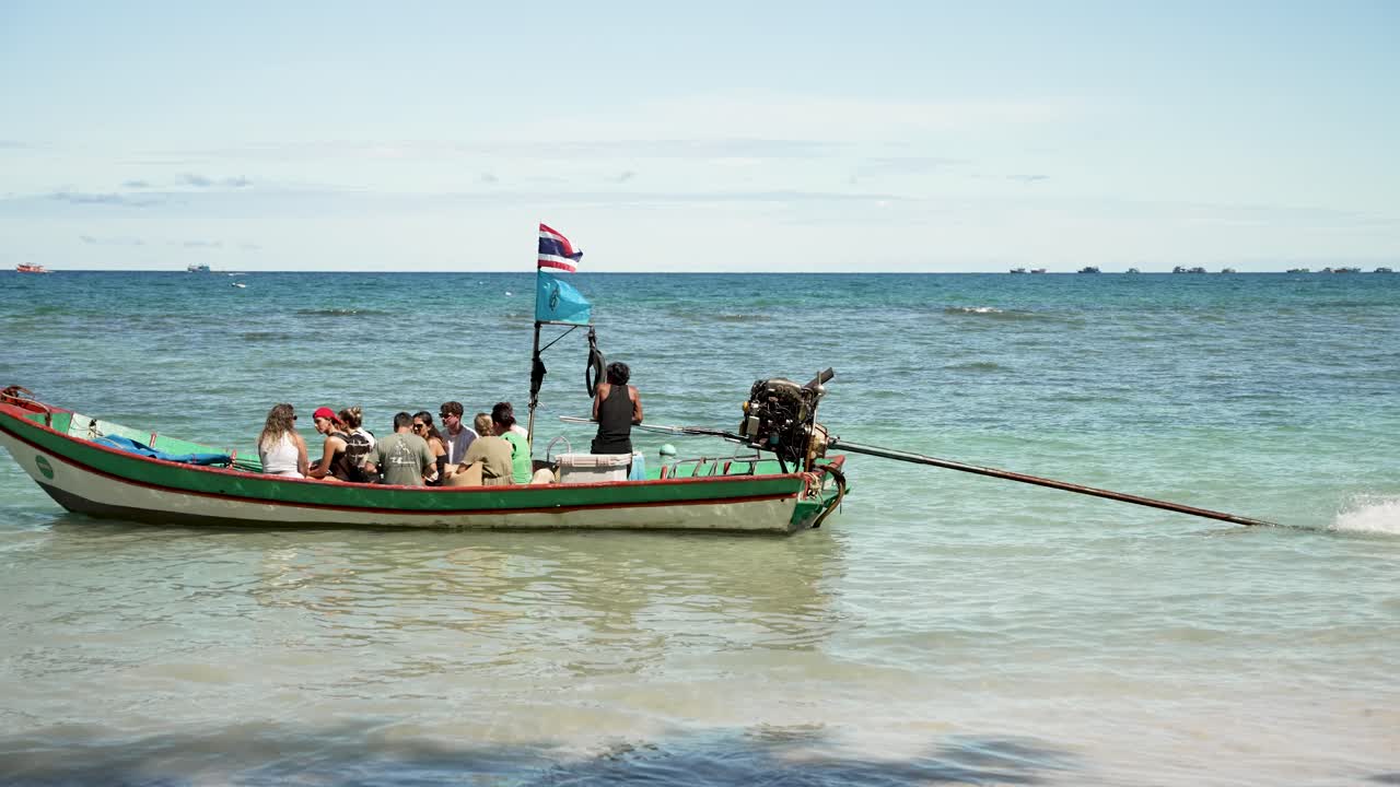 Group of tourists steps onto a boat taxi from a beach in Koh Tao, Thailand. Preparing to leave. slow motion shot
