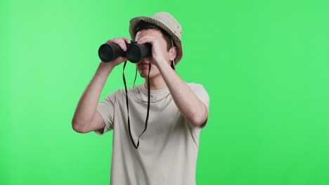 man looking through binoculars on green screen