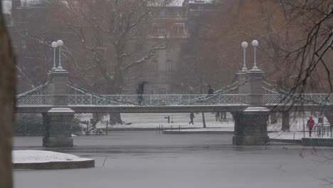 Slow-motion-of-people-walking-across-footbridge-on-a-snowy-day-in-Boston