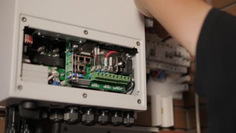 an electrician installing an inverter in a home. the image shows technical skill, modern tools, and attention to safety in electrical work