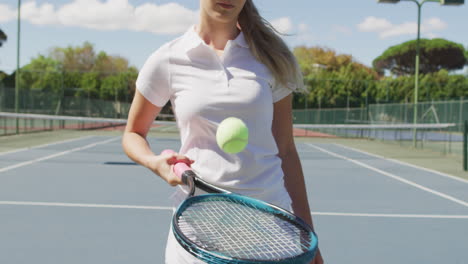 video of midsection of caucasian female tennis player holding racket and bouncing ball