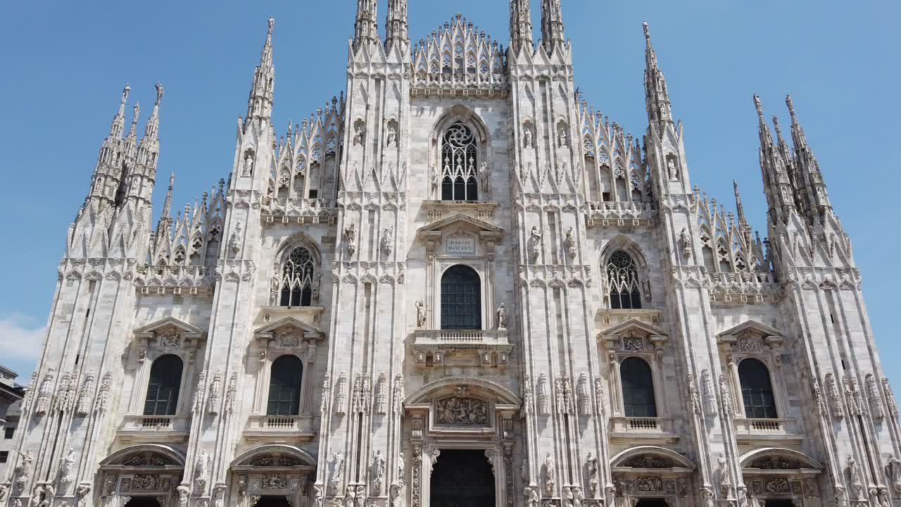 Milan duomo cathedral tilt up front view main facade gothic style against blue sly, tilt up