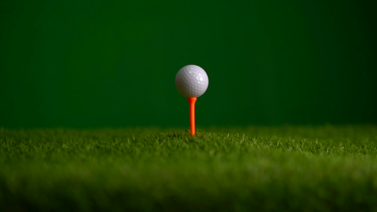 Golfbal op tee. Slow motion glijden op golfbaan op groene achtergrond