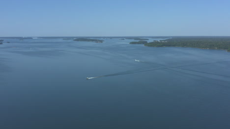 aerial panoramic wide shot of a speed boat in a blue sea archipelago