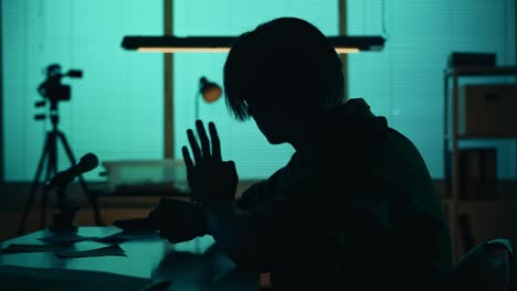 medium silhouette video of a suspect offender perpetrator or prisoner sitting in the interrogation medium silhouette video of a suspect offender perpetrator or prisoner sitting in the interrogation room he is studying the evidence on the table true crime documentary creative content