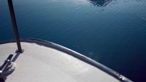 Edge-Of-Hull-Of-Boat-Floating-In-Turquoise-Water-Of-River-During-Sunny-Day