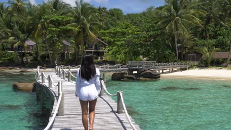 Chica-Asiática-Con-Un-Vestido-Blanco-Caminando-Sobre-Un-Puente-De-Madera-En-Una-Isla-Tropical