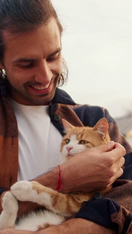 man holding a ginger cat