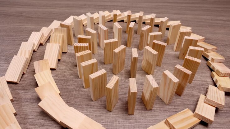 Effetto farfalla, tessere di domino circolari di legno che cadono in movimento, probabilità, possibilità future, una potente metafora per l'energia potenziale, ogni caduta che apre possibilità, un'imminente reazione a catena circolare