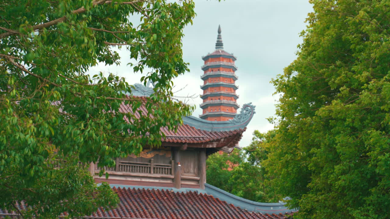 A shot of the 100-meter-tall, 13-story Bao Thap Tower, Asia's tallest Buddhist stupa, surrounded by the lush mountains and temple complex of Bai Dinh in Ninh Binh, Vietnam