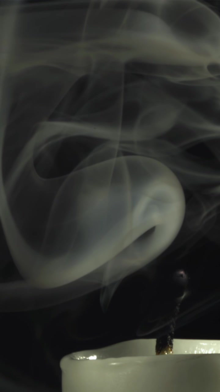 White Smoke Rising from Extinguished Candle on Black Background