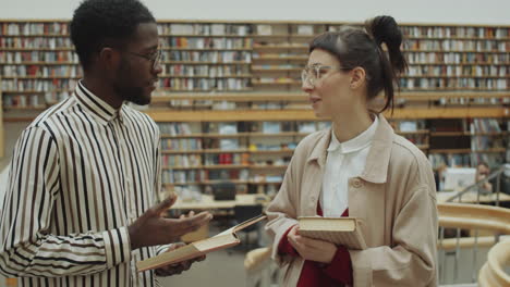 multiethnic man and woman speaking in library