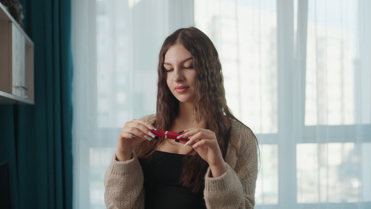 Portrait Of Woman With Lipstick, Female Model Showcasing Lipstick In Natural Light, Model Presenting Lipstick With Serene Expression In Natural Window Illumination For Commercial Photography