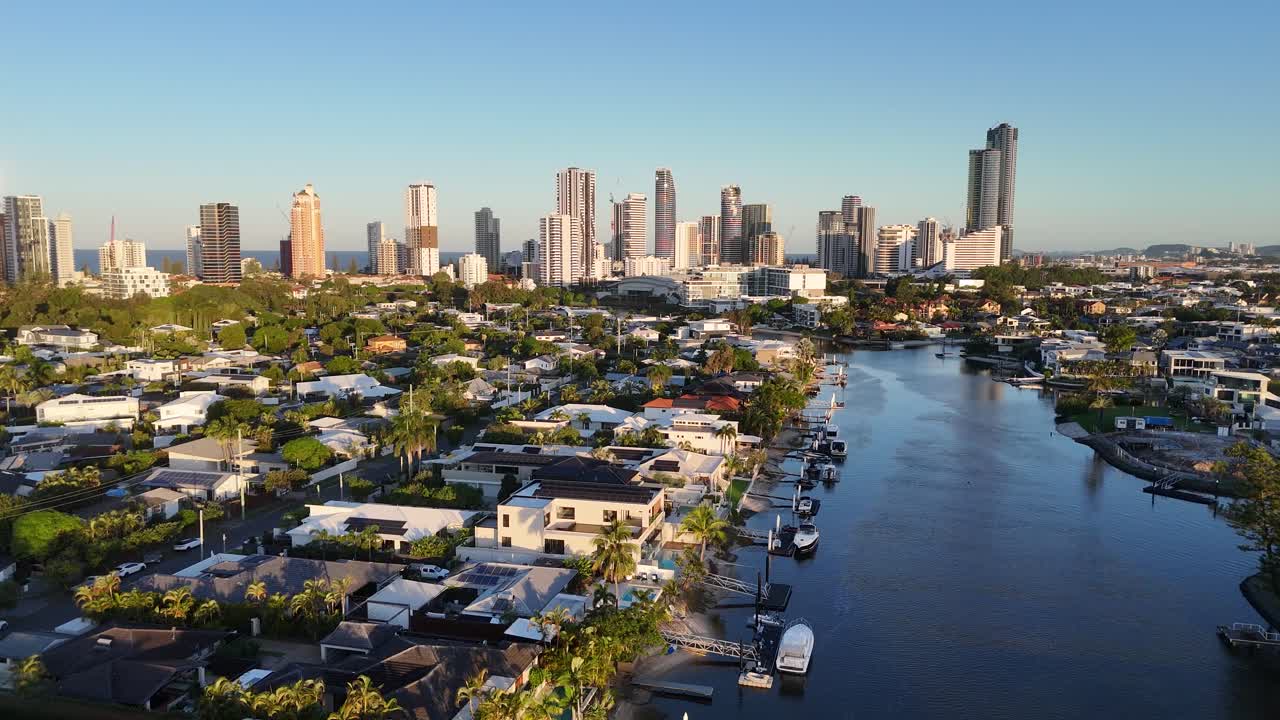 Drone footage captures Gold Coast's skyline and waterways at sunset, showcasing urban architecture and serene natural beauty