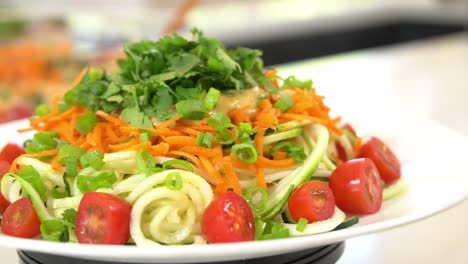 calabacín zoodles zanahorias trituradas con cilantro zoodles añadiendo al cuenco saludable vegano vegetariano estilo de vida dieta de desintoxicación