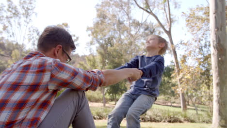 father and son playing together in a park