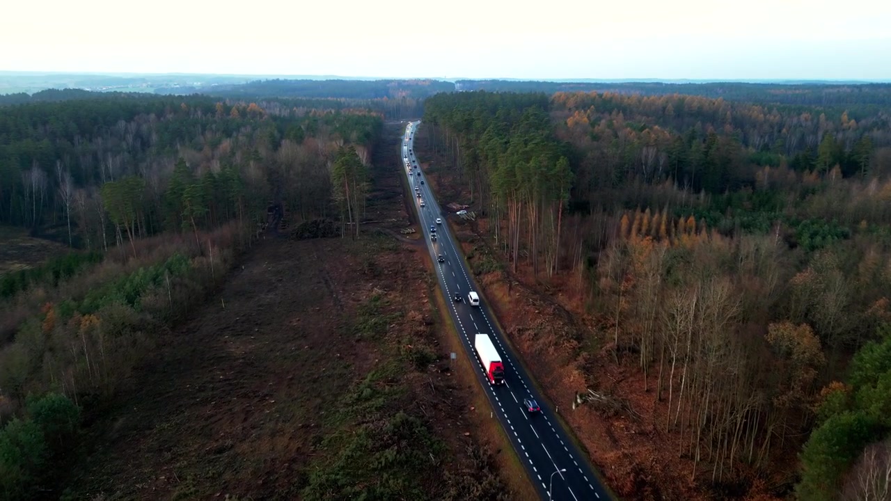 Вид с дрона на оживленную дорогу осенним утром, с видимыми автомобилями и грузовиками