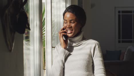 Vídeo-De-Una-Mujer-Afroamericana-Feliz-Usando-Un-Teléfono-Inteligente-En-Casa
