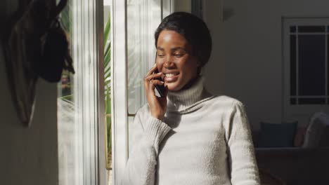 Video-of-happy-african-american-woman-using-smartphone-at-home