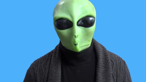 blogger in funny alien costume and home outfit sits in front of camera to record video to create interesting entertainment content for vlog. themed costume for party. gesture of fright or surprise