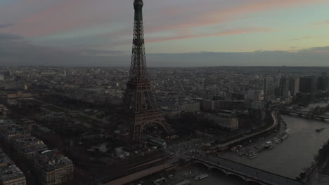 Aerial-footage-of-Pont-d-Iena-over-Seine-river,-traffic-on-waterfront-and-famous-Eiffel-Tower-at-dusk.-Paris,-France