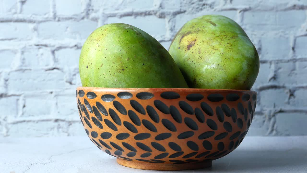 dos mangos verdes en un cuenco decorativo