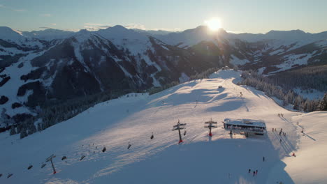 cable cars and skiers on snowy mountain zwolferkogel in saalbach-hinterglemm, austria